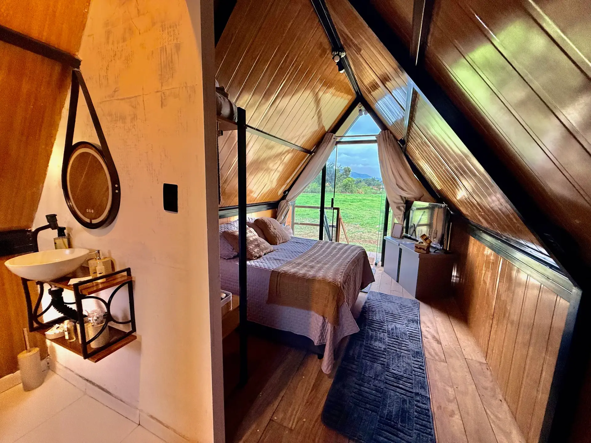 Banheiro integrado com vista para o quarto e o campo