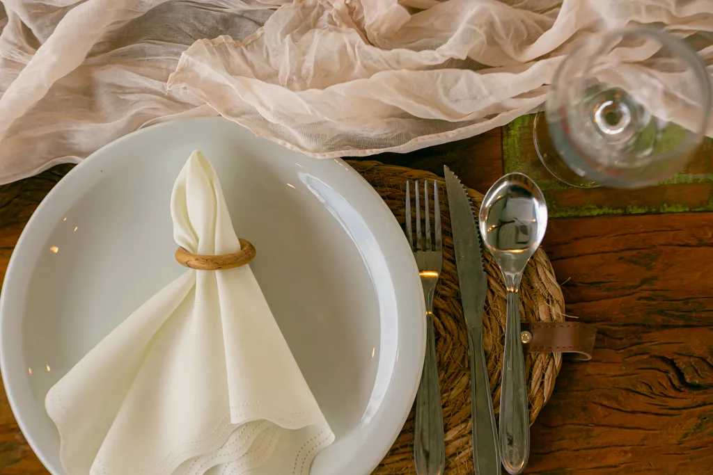 Lugar à mesa com prato, guardanapo e taça gravada