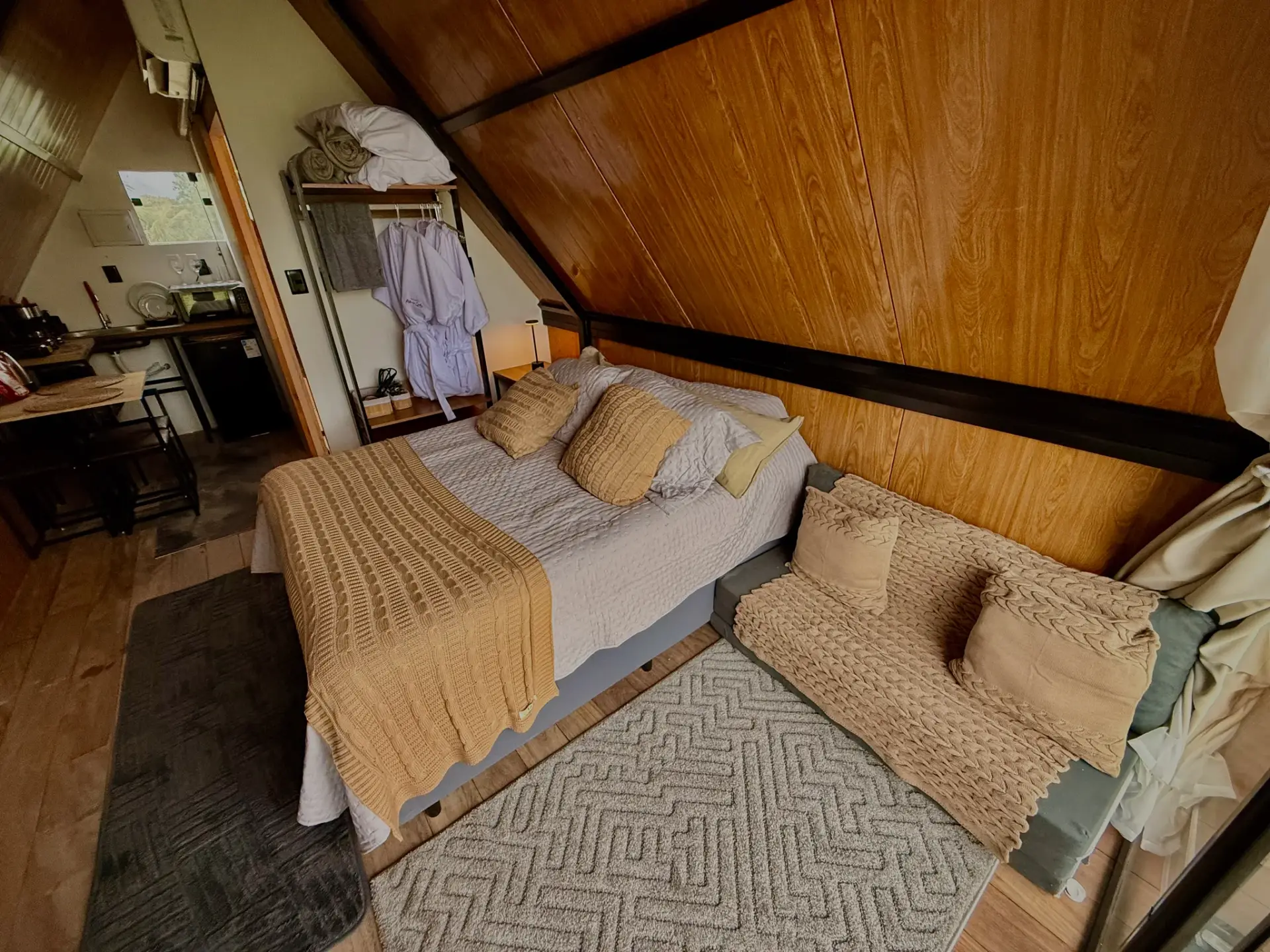 Quarto do chalé com cama de casal e sofá